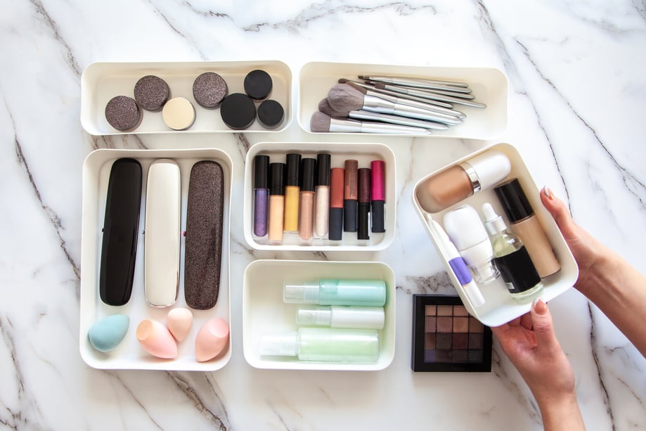 Woman hands neatly placing cosmetic and vanity items in MUJI's PP makeup storage boxes